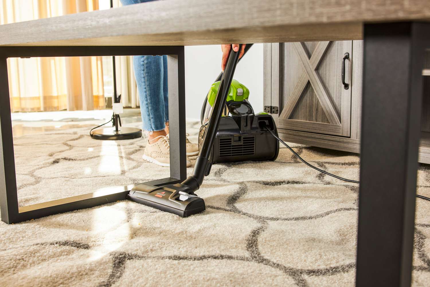 A person uses the Bissell Zing Bagless Canister Vacuum, 2156A on a carpet