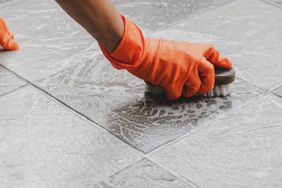 woman scrubbing floor with brush