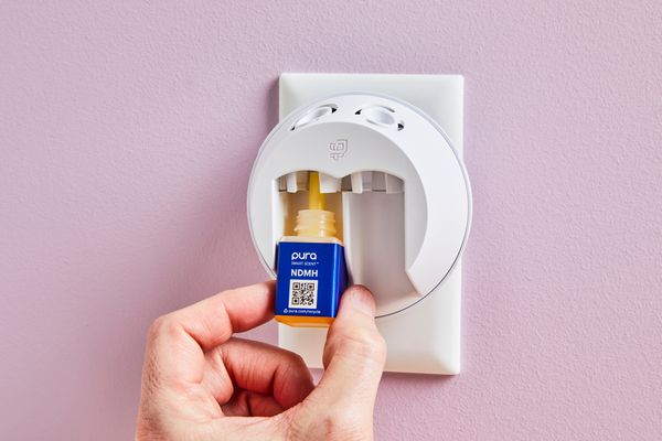 person playing a scent bottle in the Pura Smart Fragrance Diffuser