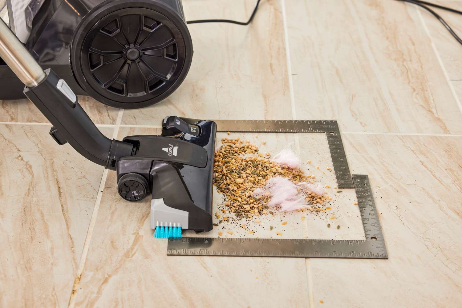 The Bissell SmartClean Canister Vacuum is used to vacuum a wooden floor