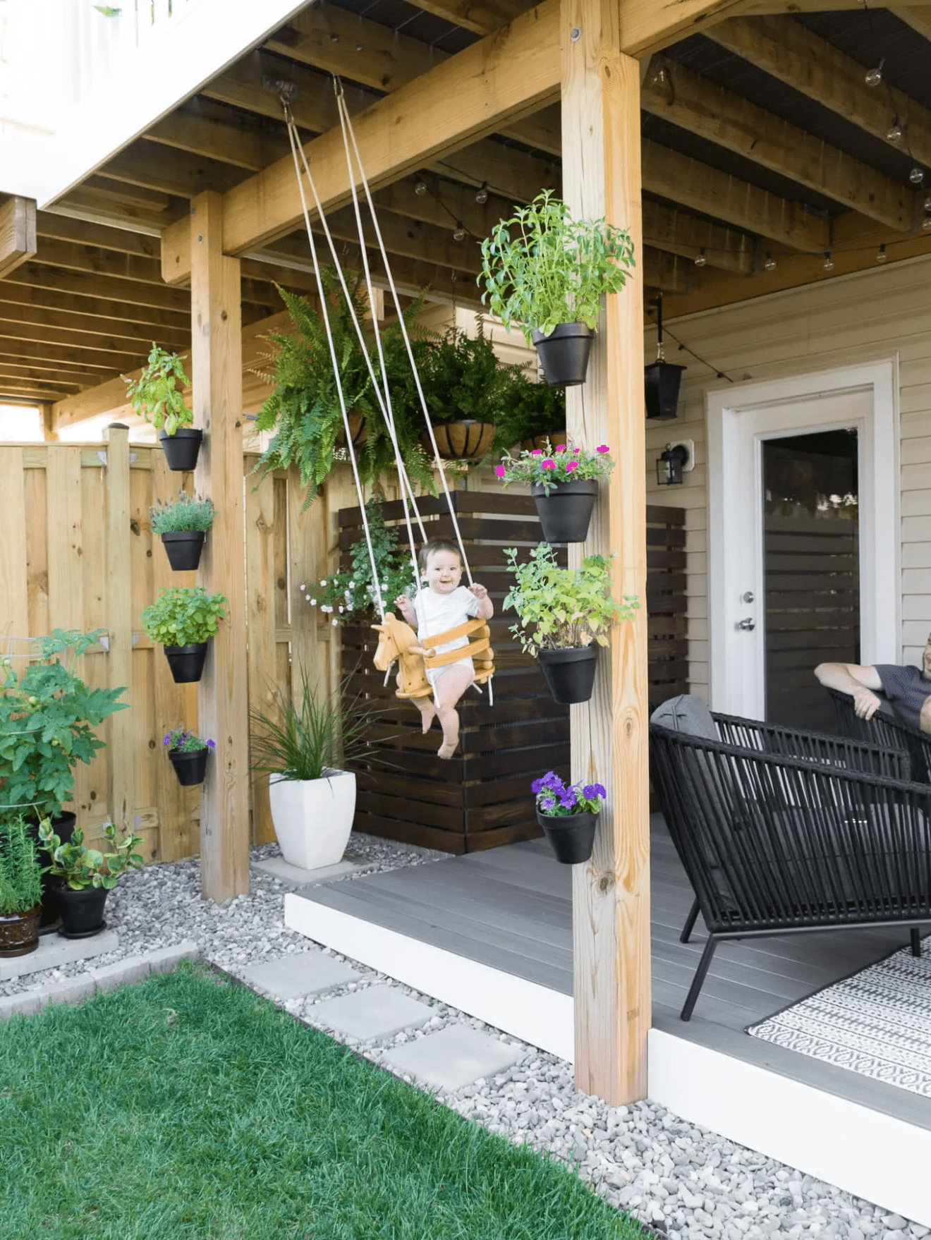 Small backyard ideas, child in swing in small outdoor area