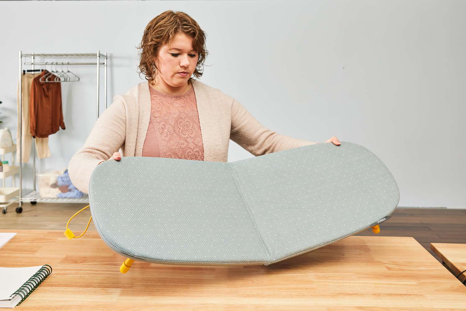 A person folding out the Joseph Joseph Pocket Folding Ironing Board