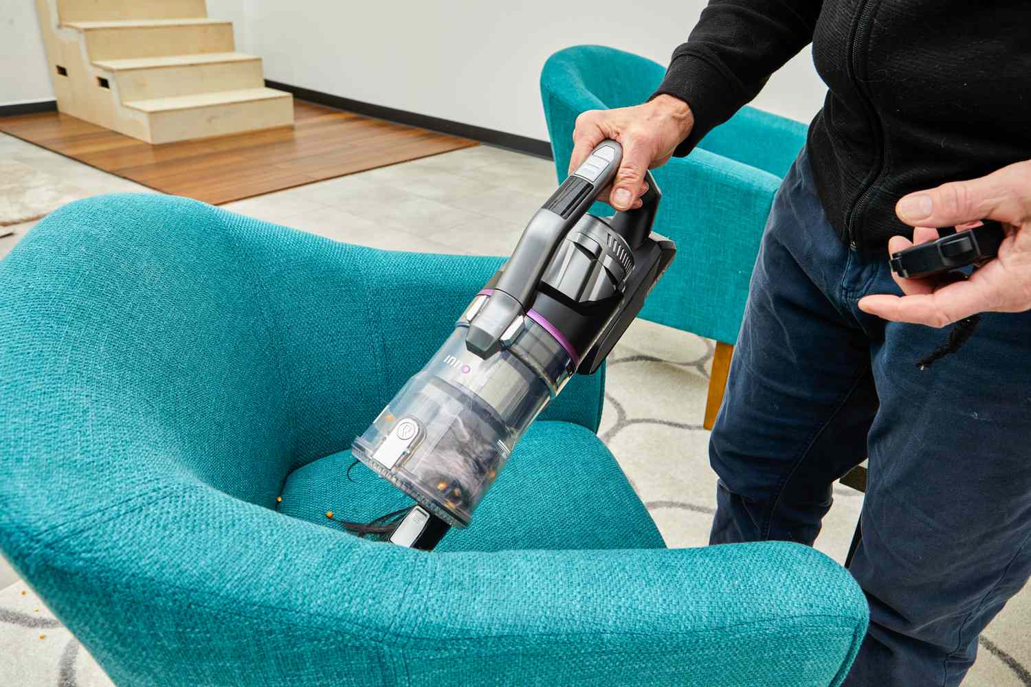 Person blue chair with a Innova Cordless Stick Multi-Surface Vacuum 