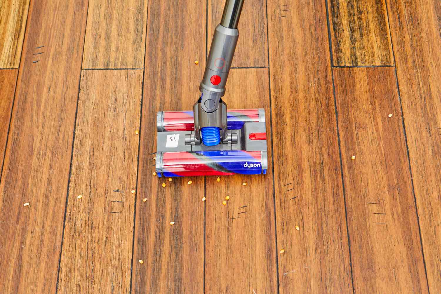 Dyson Omni-Glide+ Cordless Vacuum cleaning popcorn kernels from the hardwood floor