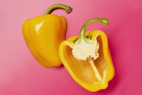 Still life of sliced yellow bell peppers on pink background