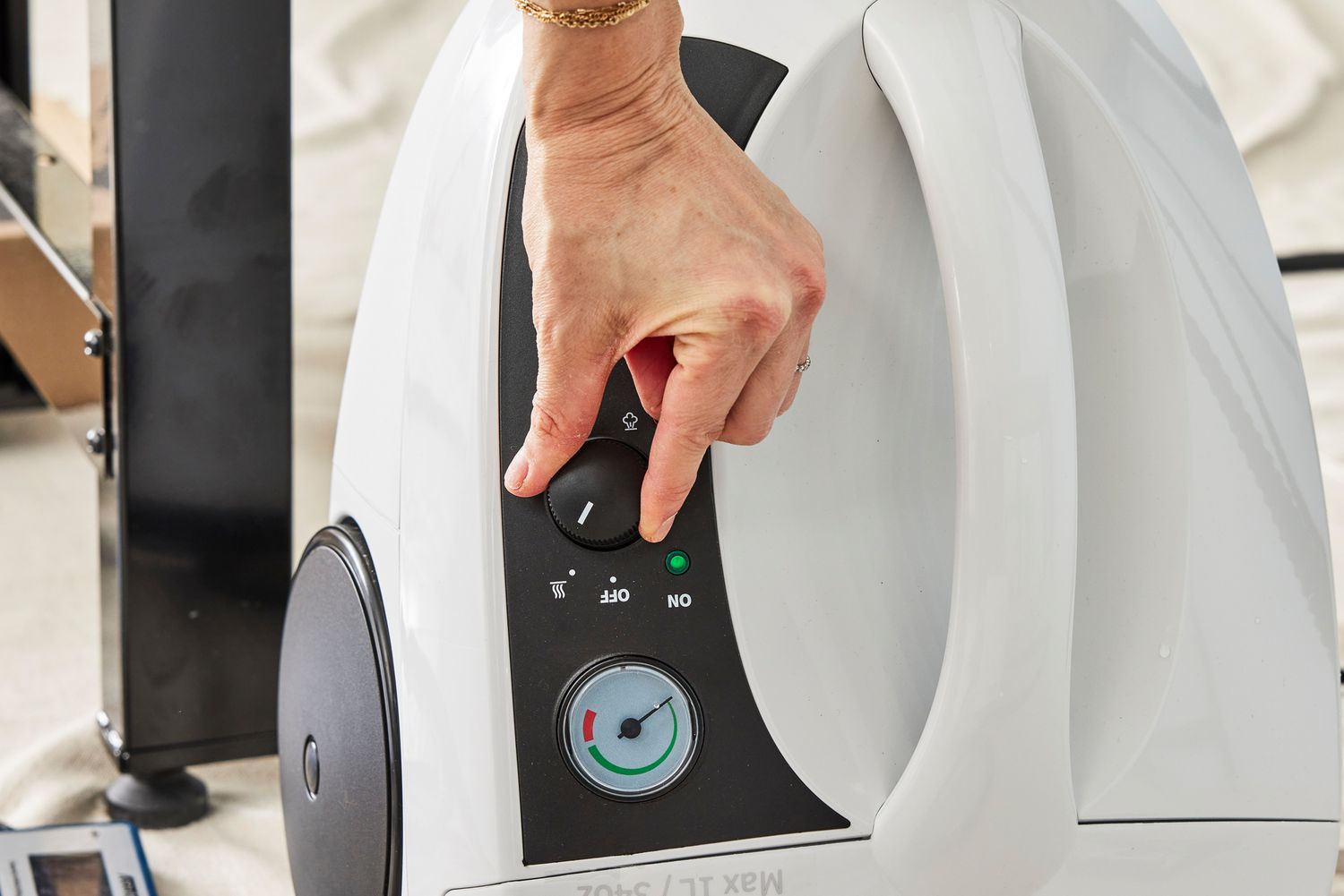 A hand adjusts a dial on the Dupray One Steam Cleaner