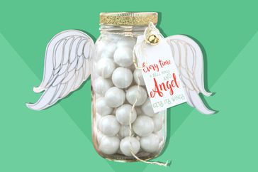 Mason jar filled with pearlized gum balls, decorated with a pair of paper wings to look like an angel, with a gift tag that reads "Every time a bell rings an angel gets its wings"