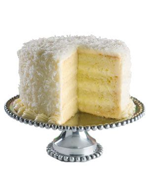 Coconut Layer Cake on a Cake Stand With a Slice Cut Out
