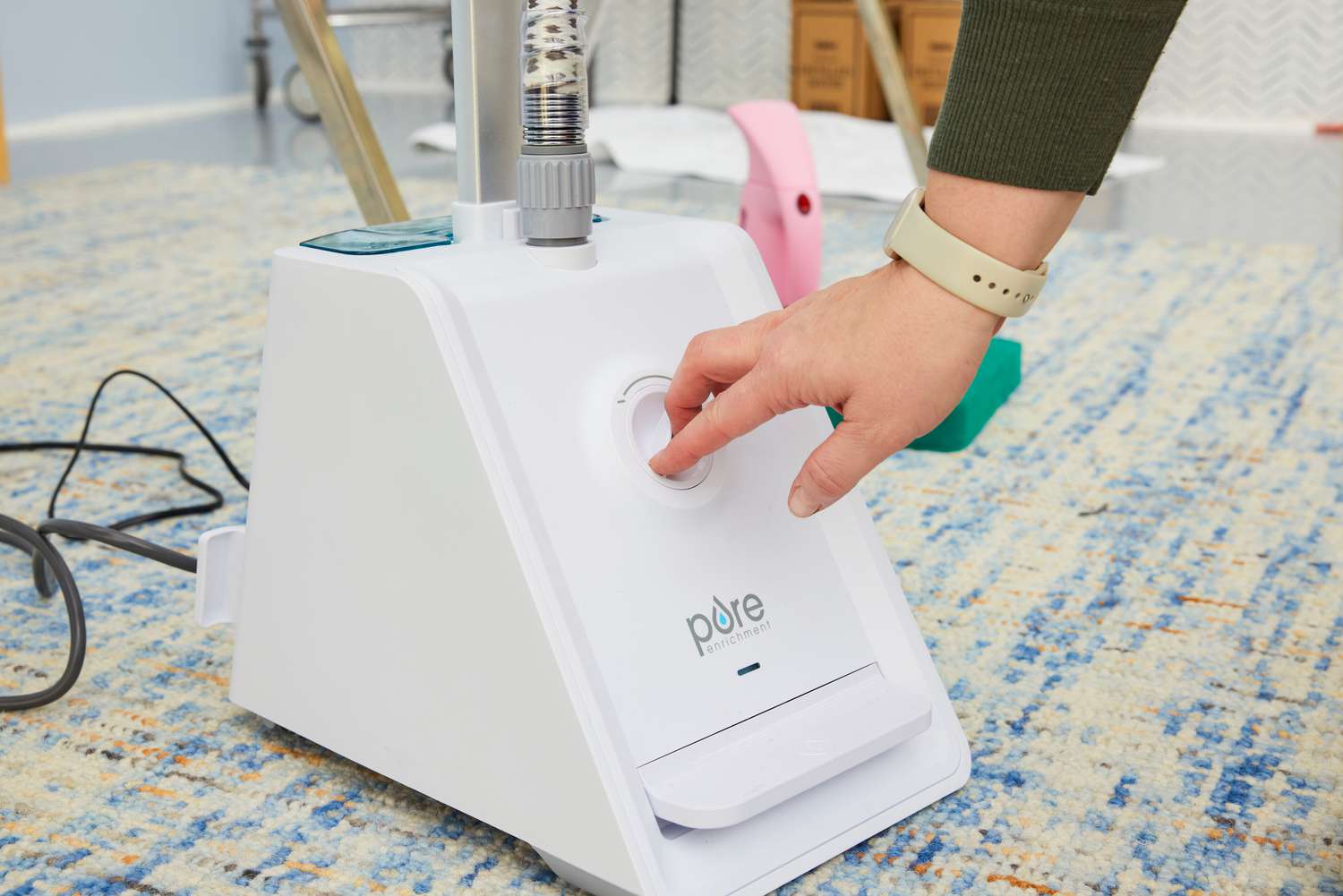 Close-up of a hand changing the steam dial on the Pure Enrichment PureSteam Pro Upright Clothes Steamer.