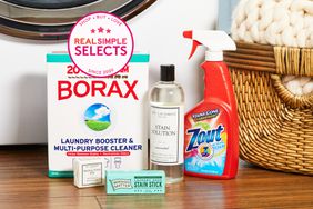 Several laundry stain removers we recommend displayed on a laundry room floor