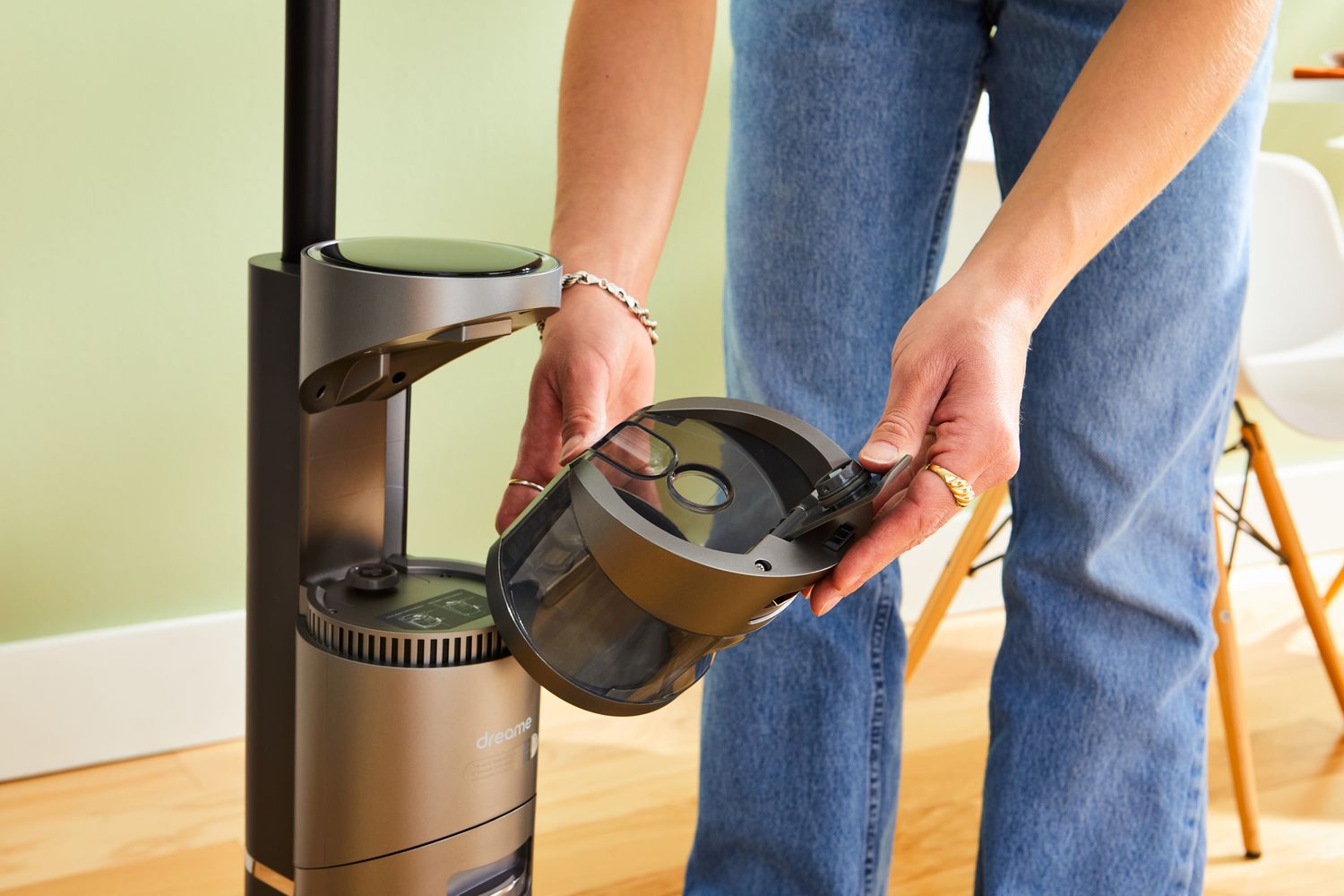 A person holding a compartment from the Dreametech H11 Max Wet and Dry Vacuum