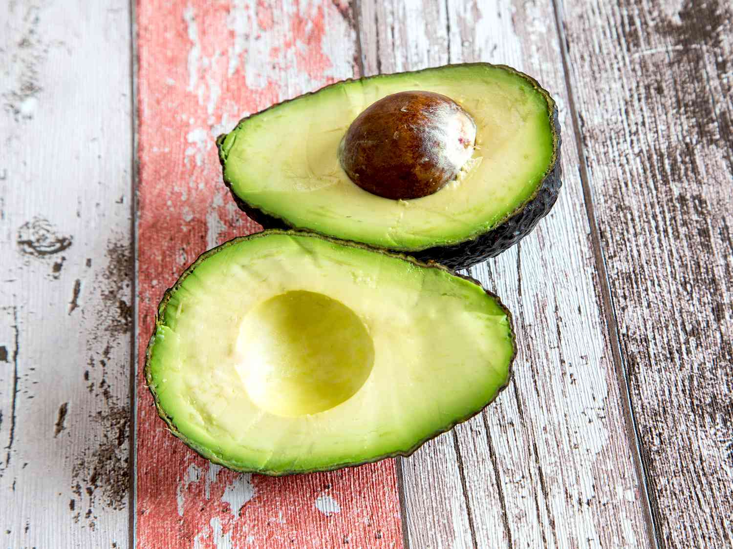 A slices avocado on a textured wooden surface