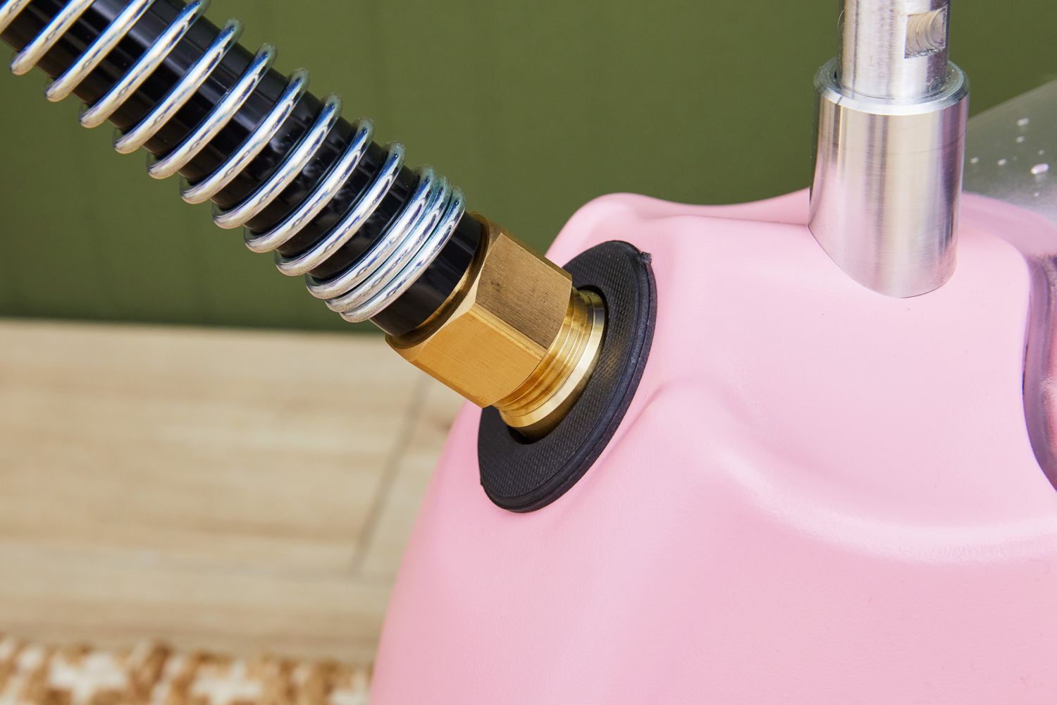 Close-up of the hose connecting to the tank of the Jiffy J-2000 Floor Standing Fabric Steamer.