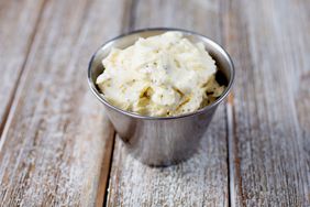 small metal container of roasted butter on a wooden surface