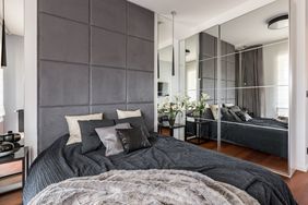 Bedroom with gray headboard and mirrored closet doors