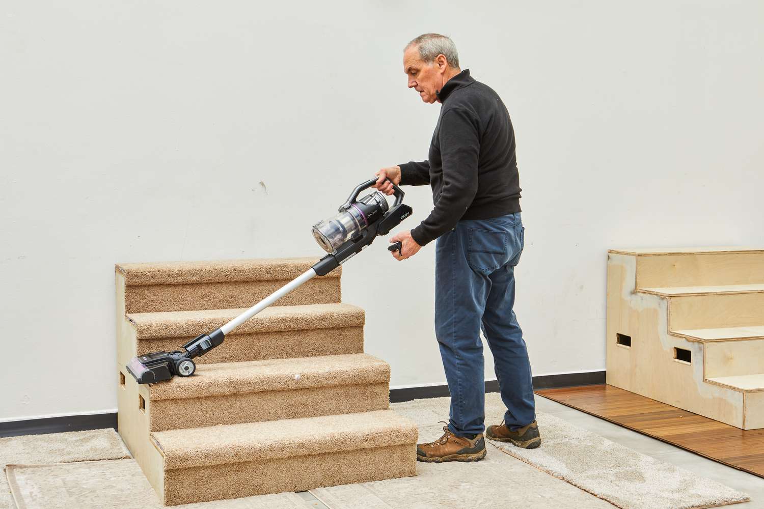 Person cleaning spills from beige carpet using Innova Cordless Stick Multi-Surface Vacuum