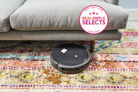 iRobot Roomba Robot Vacuum on a colorful carpet in front of a couch