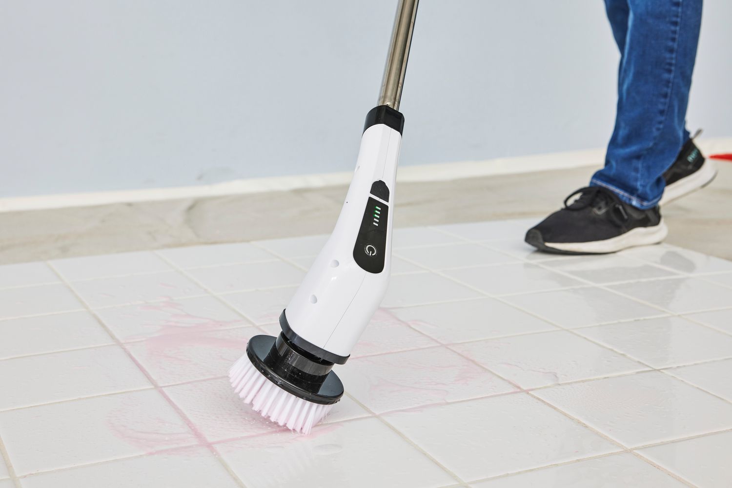 Person cleans white tile with a Losuy Electric Spin Scrubber