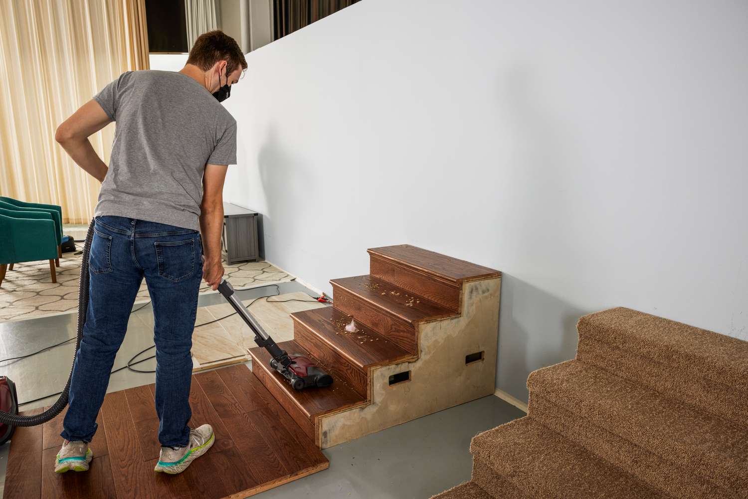 A person uses the Kenmore 400 Series Bagged Canister Vacuum 81414 on wooden stairs
