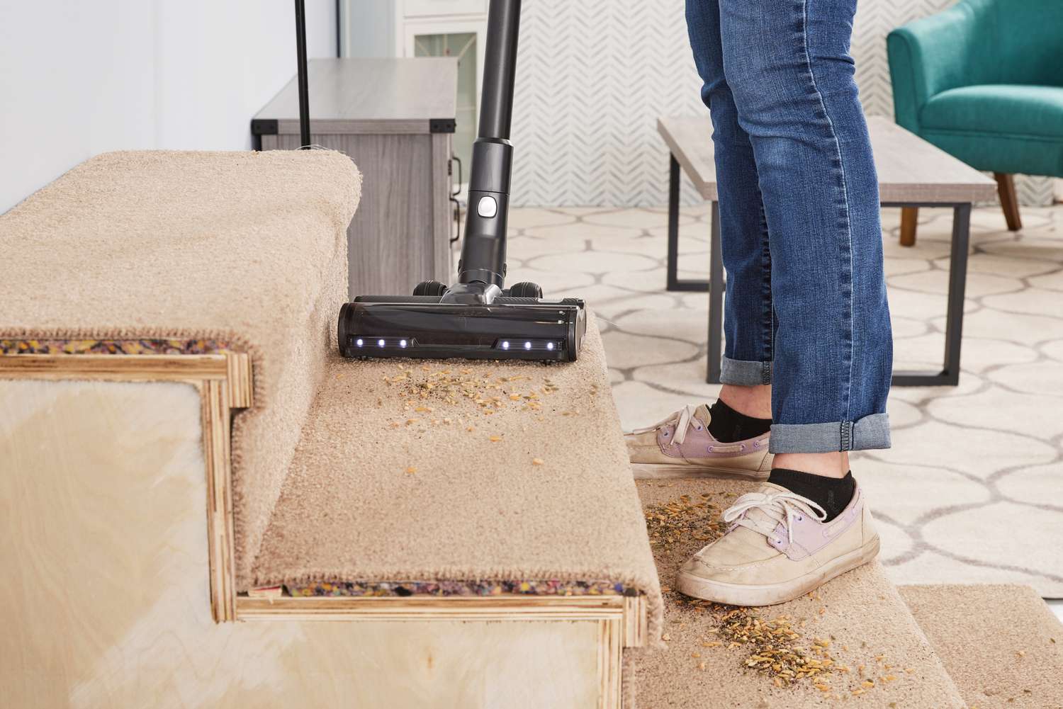 A person using the Levoit VortexIQ 40 Cordless Stick Vacuum to vacuum food off carpeted stairs.