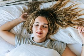 Woman asleep in bed - best sleeping position for aging