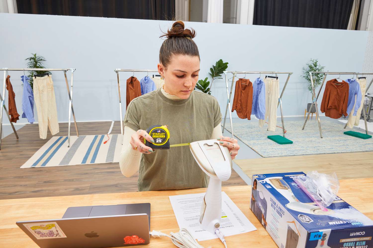 A person measuring the size of the Conair Turbo ExtremeSteam Hand-Held Fabric Steamer.