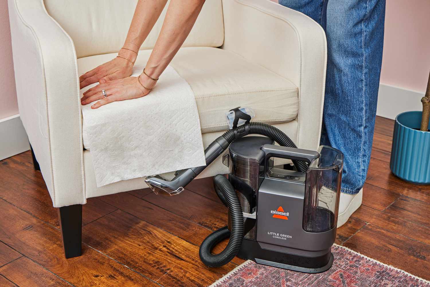 A person dries upholstery after using the Bissell Little Green Cordless Portable Carpet Cleaner 3682