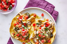 Slow-cooker Chicken Tostadas with toppings on a white plate with a purple cloth napkin