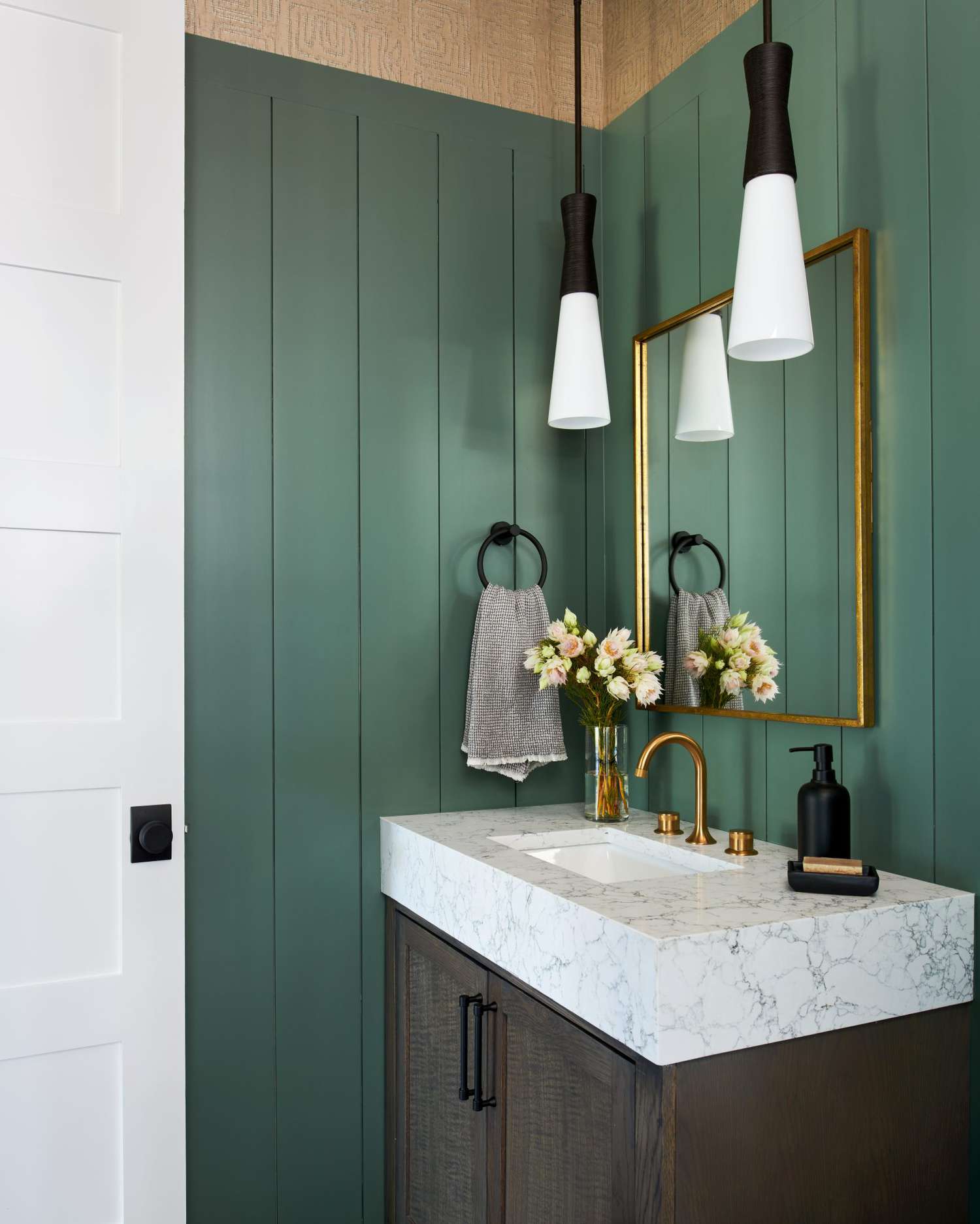 bathroom with dark sage green paint and hanging light fixtures