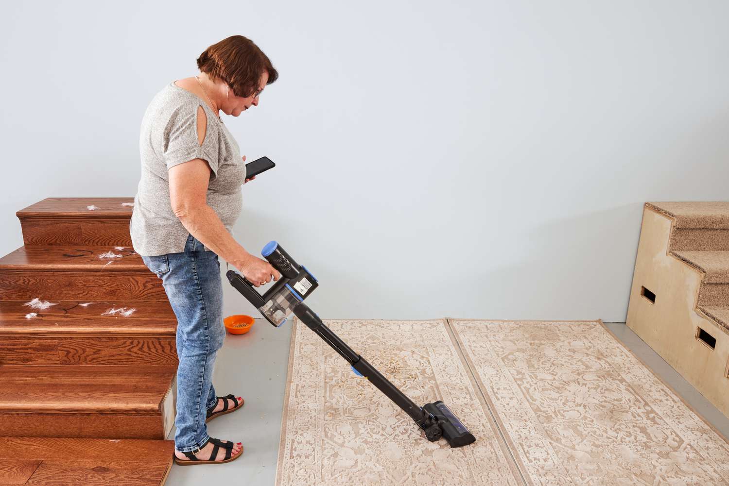 A person using the WOWGO Cordless Vacuum Cleaner to clean a rug.