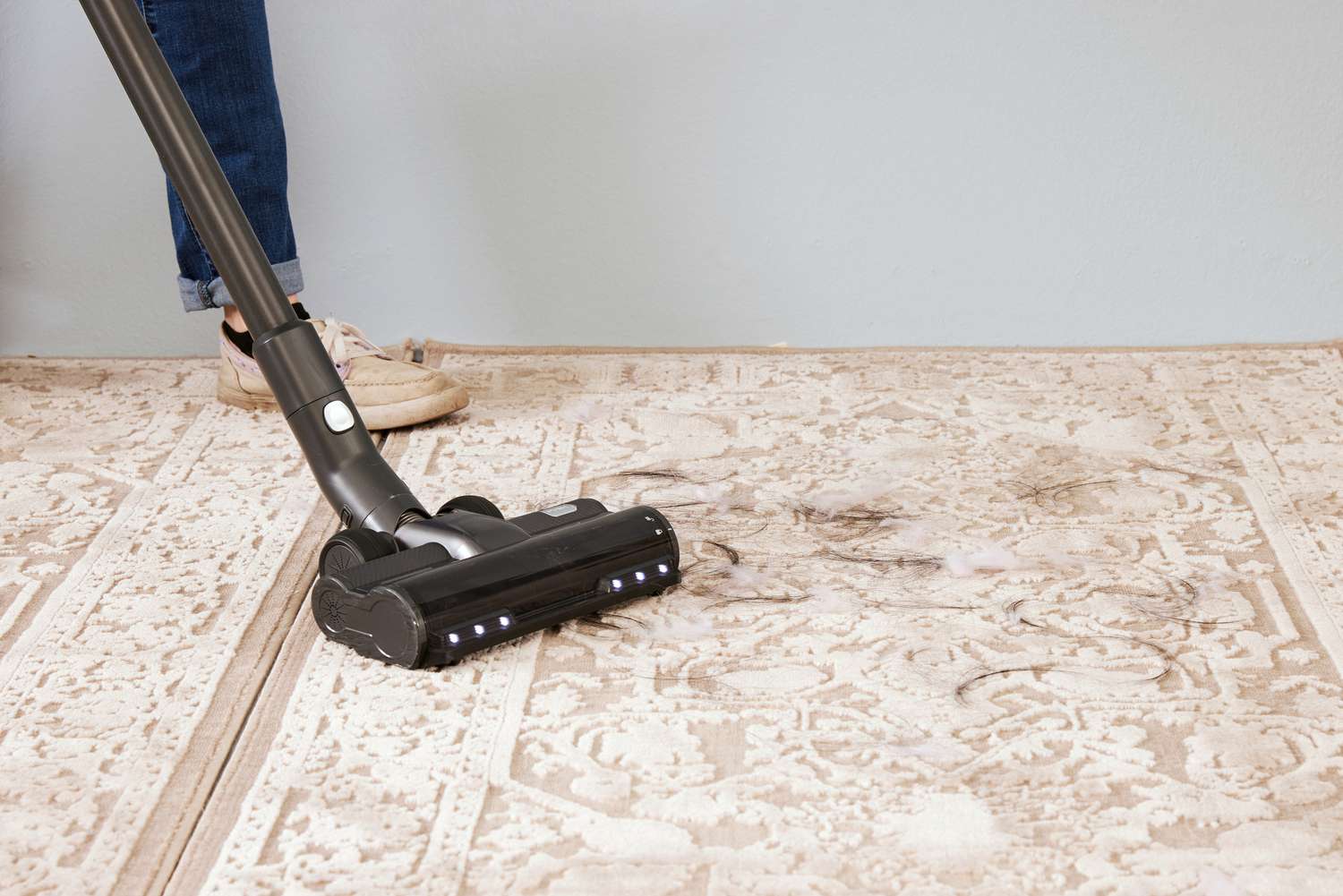 The Levoit VortexIQ 40 Cordless Stick Vacuum being used to vacuum hair off a rug.