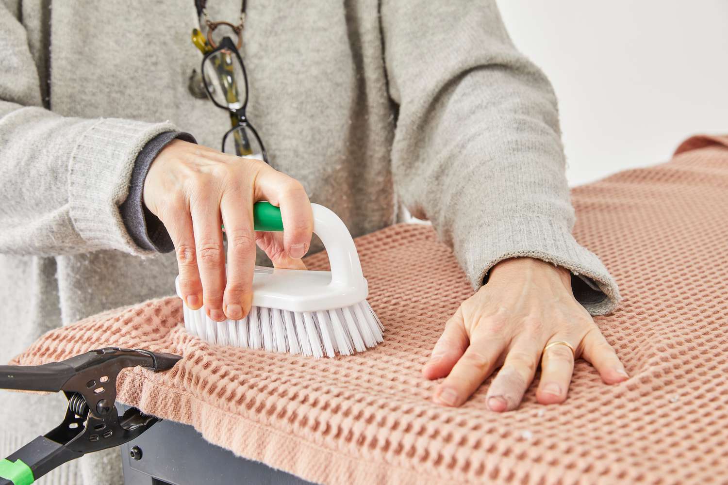 A person using a brush on a towel from The Citizenry Mara Organic Waffle Bath Towel Set