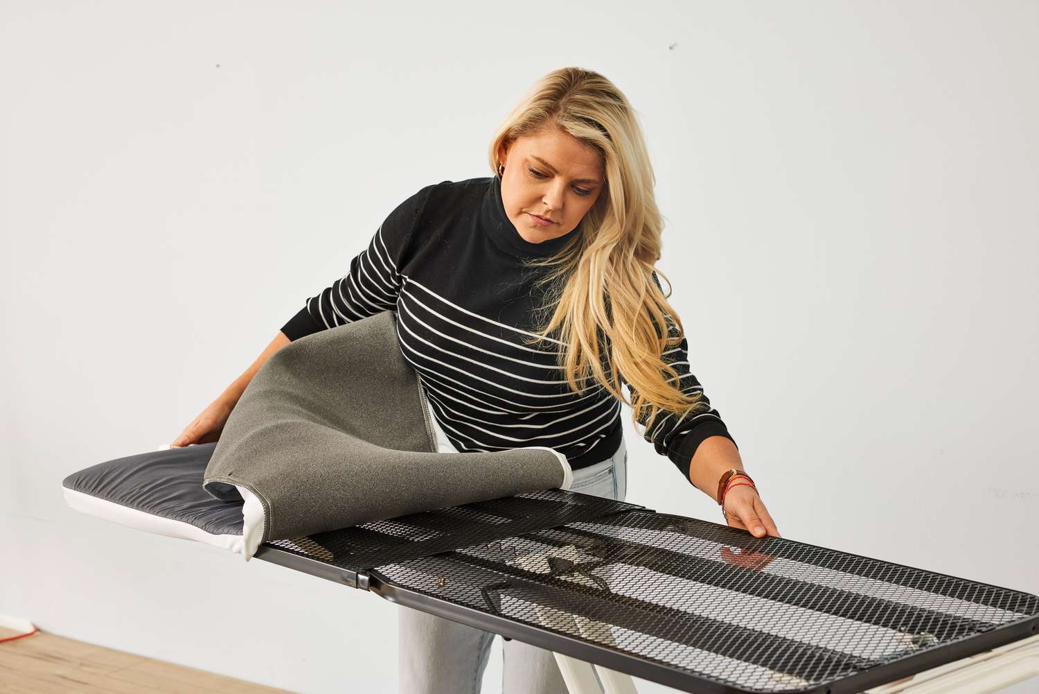 A person assembling the Reliable 320LB Home Ironing Board