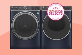 A dark washer and dryer set on a two-toned peach background