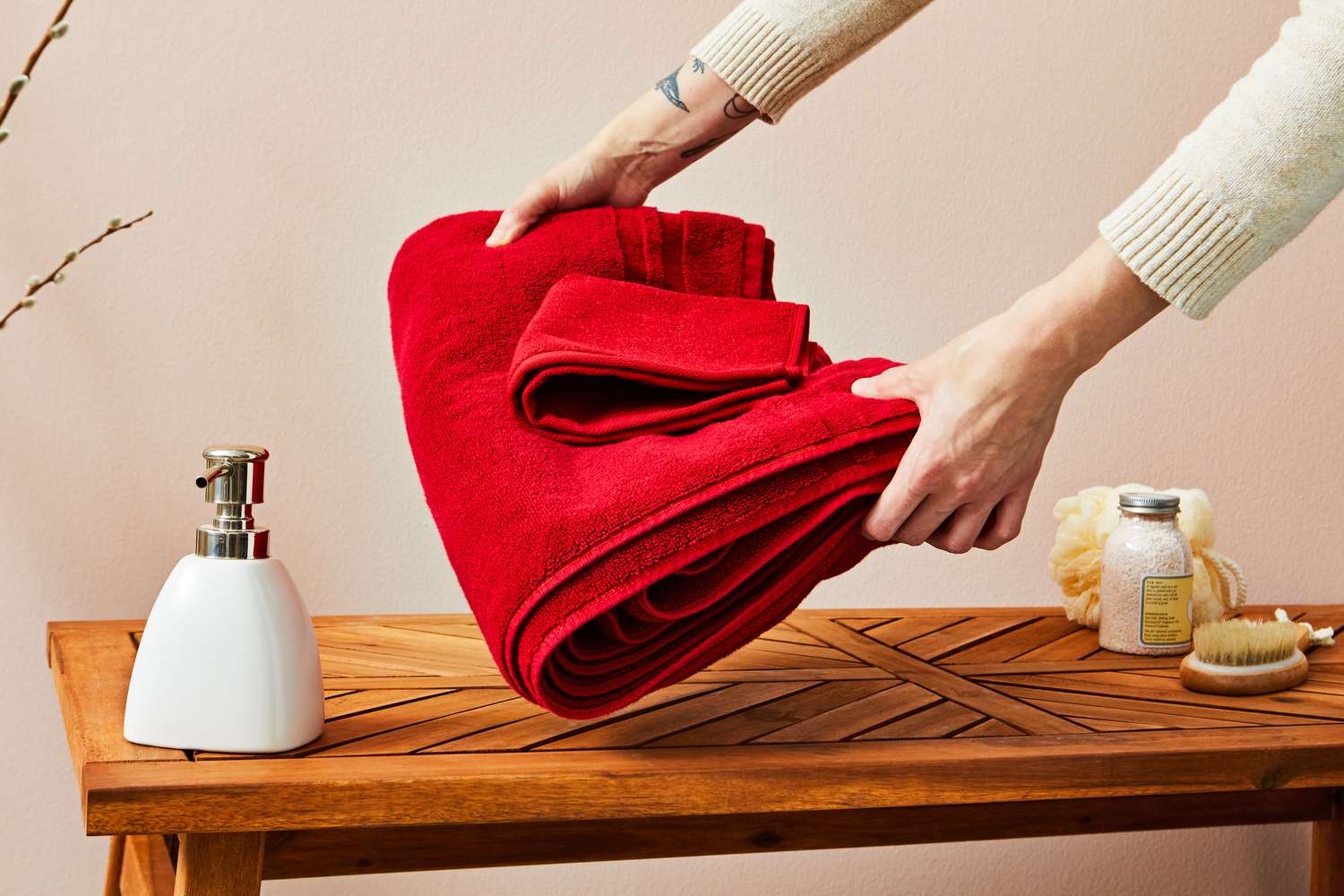 Person placing Ralph Lauren Payton Towel Collection on wooden table