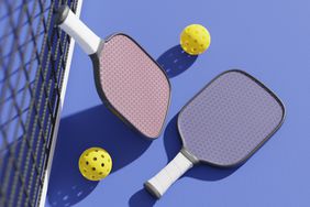 Rackets and balls for playing pickleball at the sports net on the court. 3D rendering