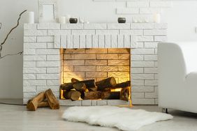 White fireplace in light room with fire wood