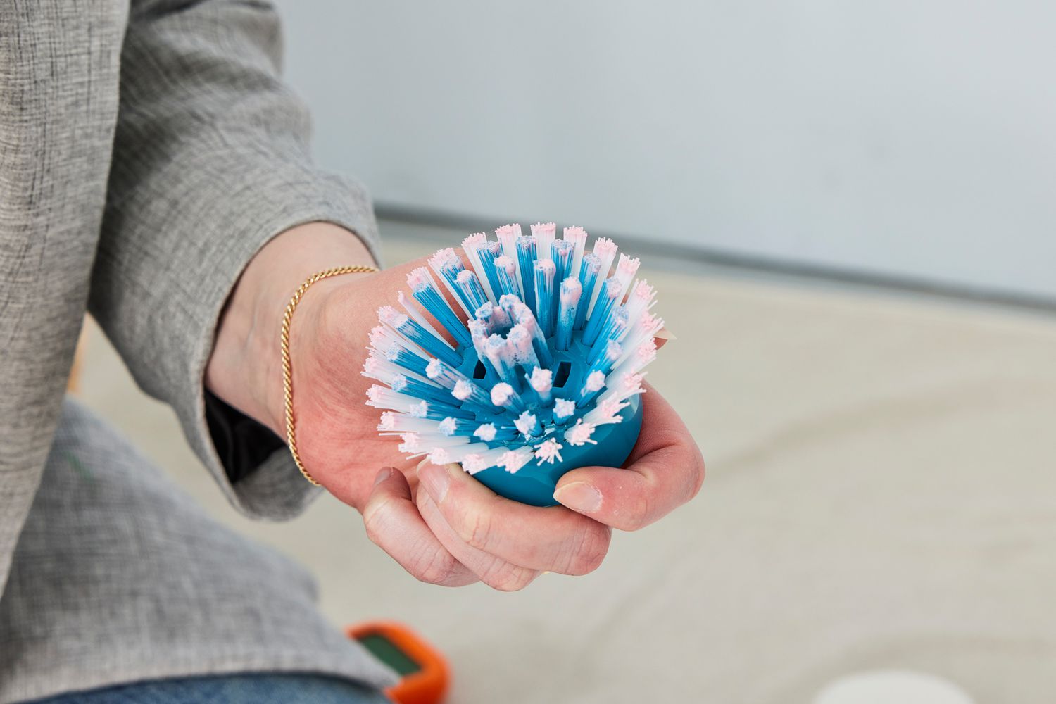 Person holds the bristle brush for a Black+Decker Grimebuster Pro Power Scrubber Brush