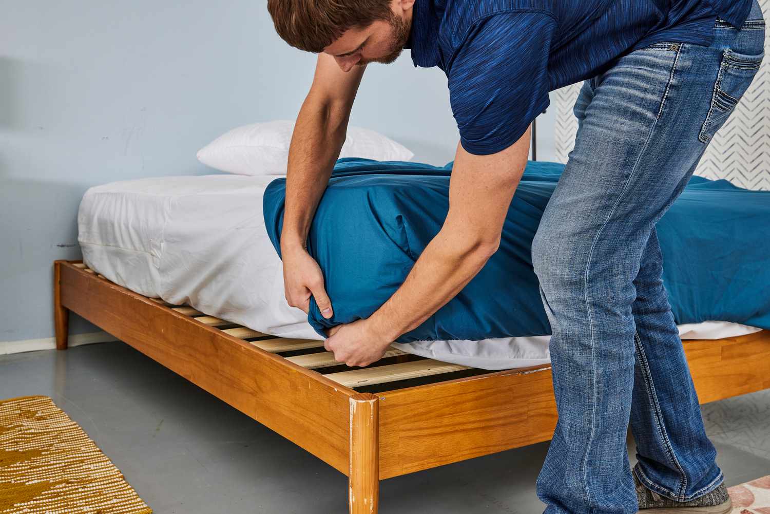 A person placing the Comfort Spaces Coolmax Moisture Wicking Sheet Set on the corner of a mattress