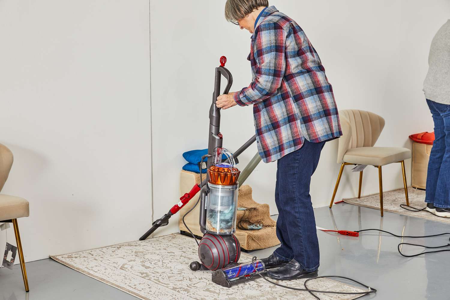 A person using a Dyson Ball Animal 3 Extra nozzle to the edge of a rug