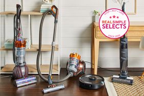 Four vacuums set up next to each other in a living space