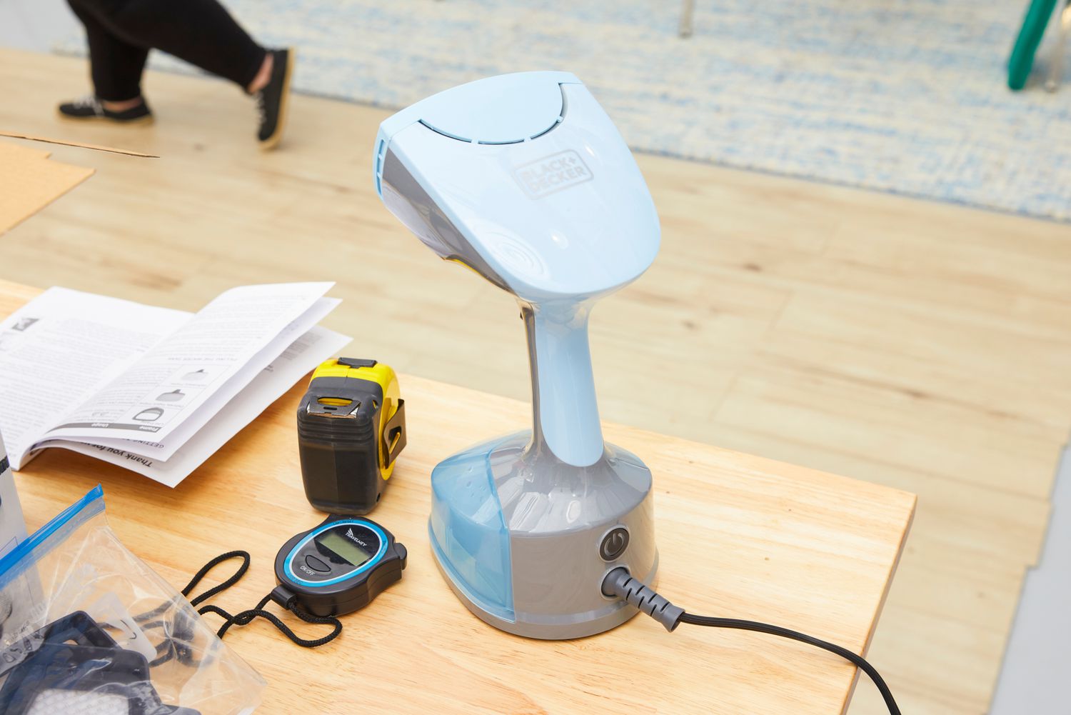 The BLACK+DECKER HGS200 Advanced Handheld Steamer sitting on a table. 