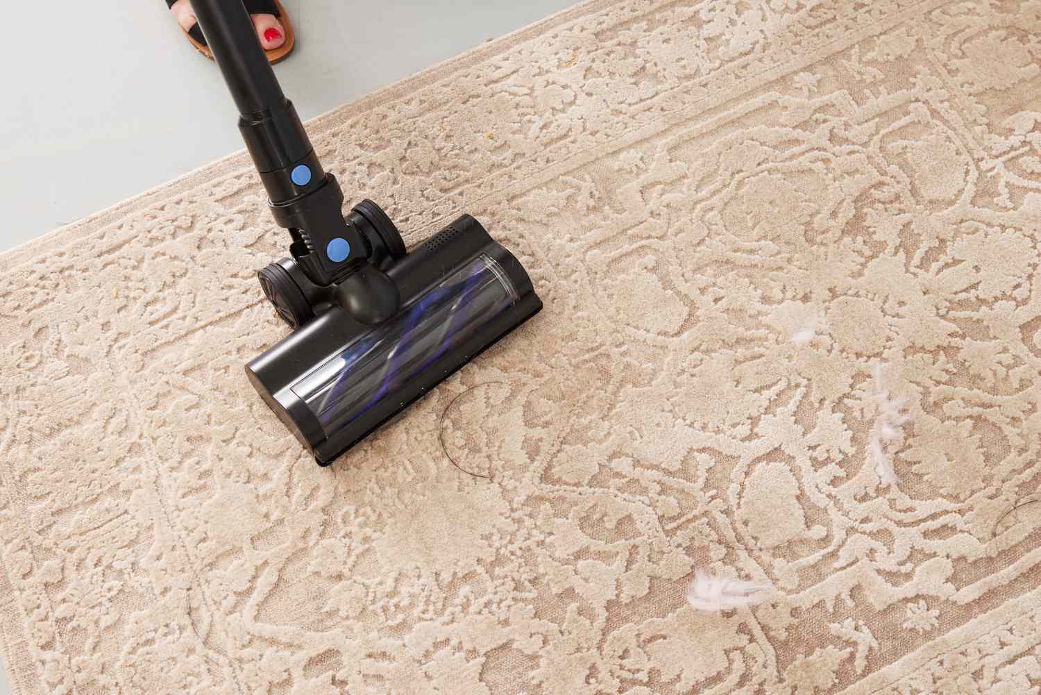 A close-up of the WOWGO Cordless Vacuum Cleaner's motorized brush head being used on a rug.