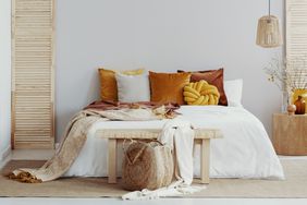 Bedroom with white duvet and colorful pillows, pendant lamp 