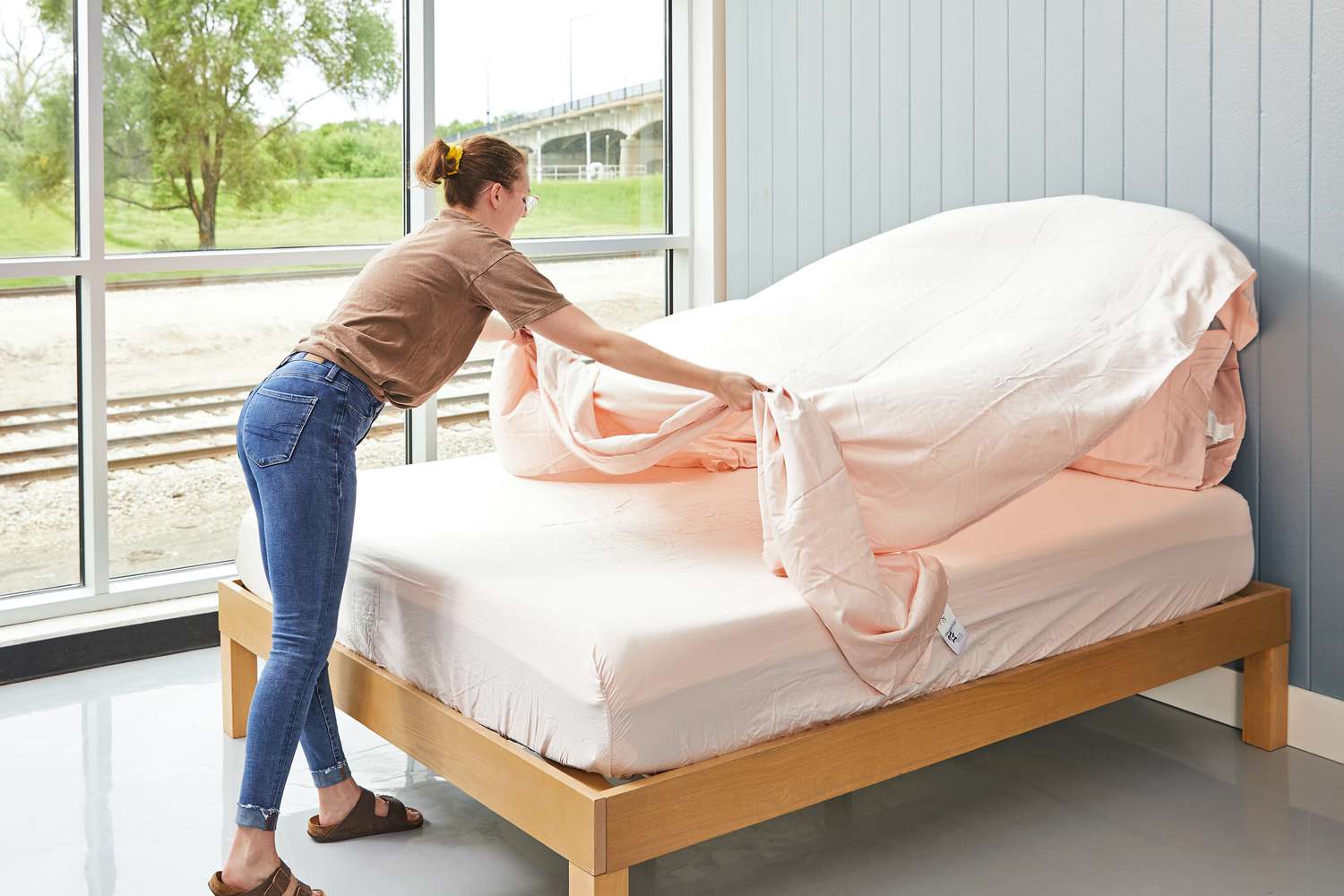 Person spreading a Linenwalas 100% Tencel Lyocell Bed Sheet over a mattress