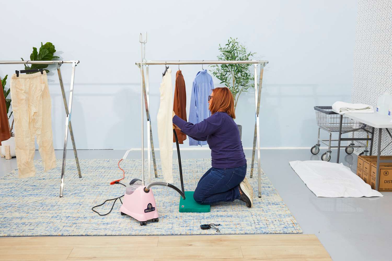 Person steaming pants with the Jiffy J-2000 Floor Standing Fabric Steamer