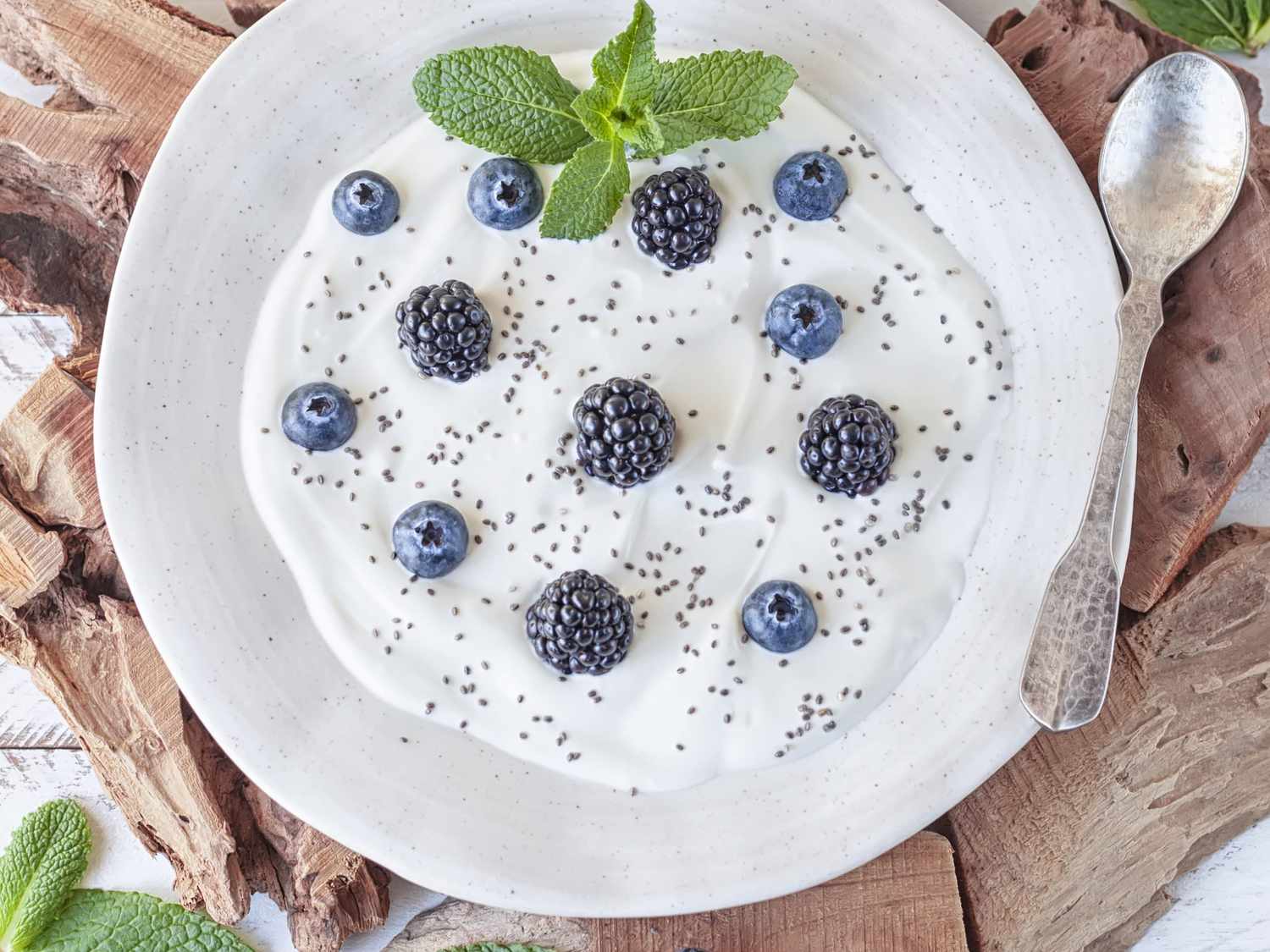 High-Calcium Foods: Greek yogurt with blackberries, blueberries and chia seeds on a white wooden rustic table