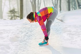 Cold Weather Exercise Risks and Tips: Woman stretching outside in the snow