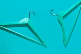 Teal clothes hangers on blue background