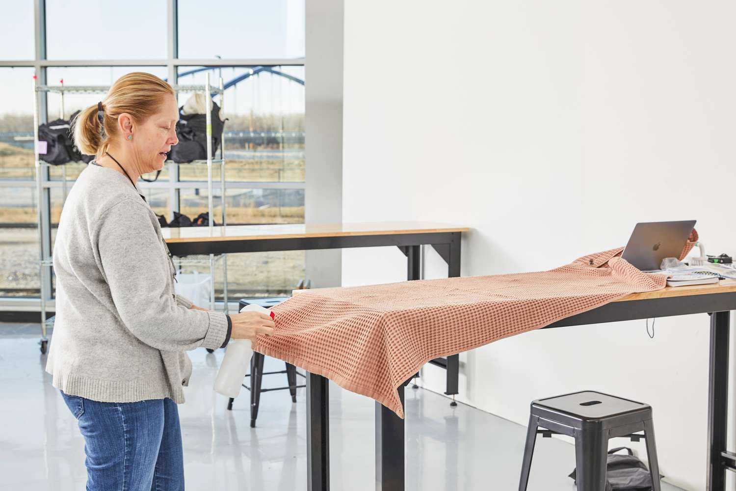 A person using a spray bottle on a product from The Citizenry Mara Organic Waffle Bath Towel Set